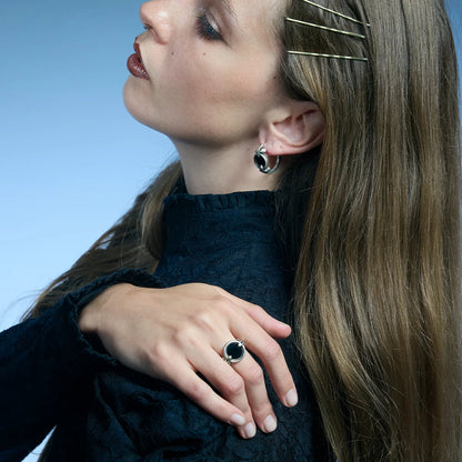 Side portrait showing an antiqued silver Scrying Mirror Ring worn on the hand with its black obsidian center facing upward.