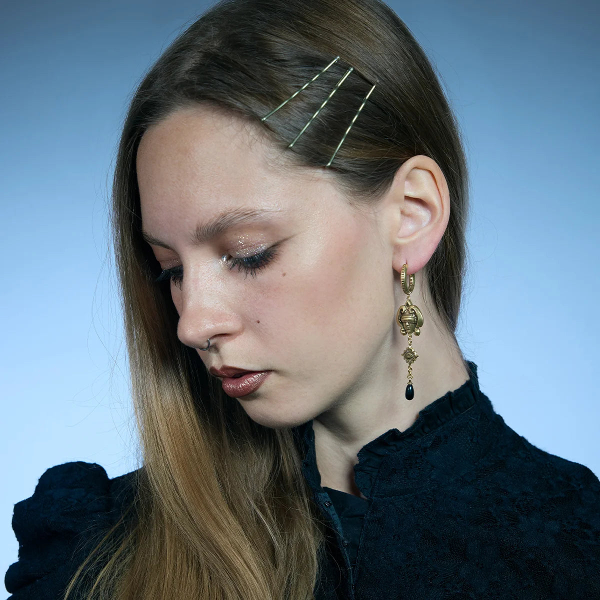 Gold-tone Second Sight Drop Earrings worn in a downward-looking portrait, highlighting their elongated articulated design.