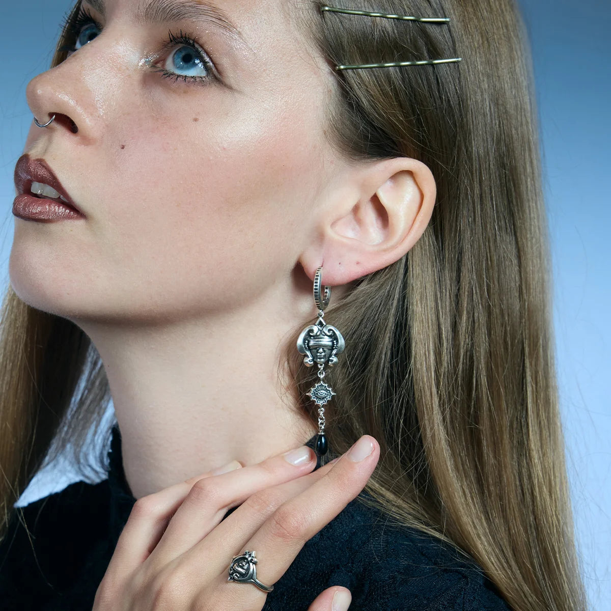 Low-angle portrait showing antiqued silver-tone Second Sight Drop Earrings hanging along the jawline.