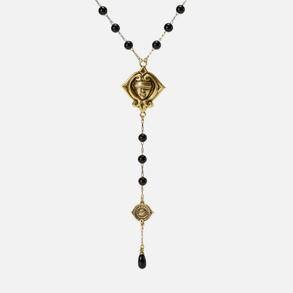 Gold-tone Second Sight Lariat Necklace displayed from the front with black beads, symbolic medallions, and a black teardrop.