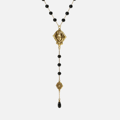 Full-length front view of the gold-tone Second Sight Lariat Necklace with black beads, linked emblems, and a black teardrop.