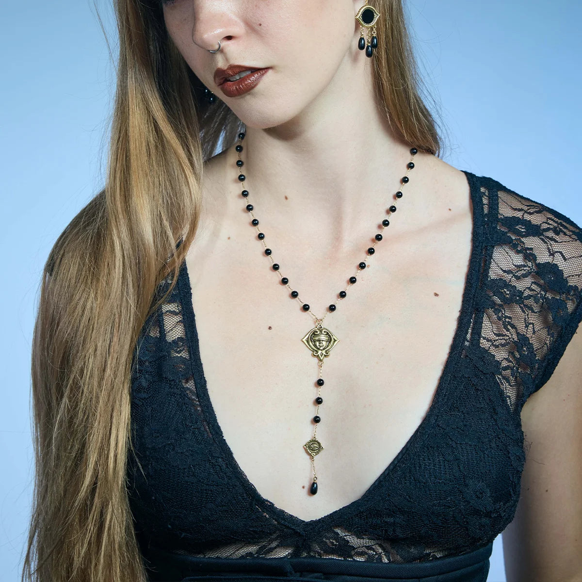 Front portrait showing an antiqued silver-tone Second Sight Lariat Necklace extending vertically over a black lace top.