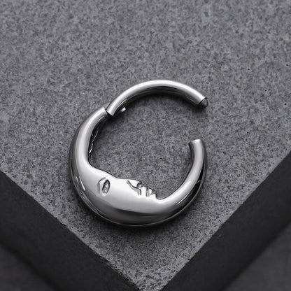 Open silver Serene Face titanium clicker displayed on a gray block
