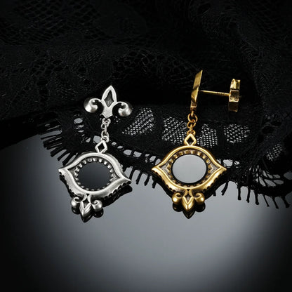 Antiqued silver- and gold-tone Silent Lens Drop Earrings displayed together against black lace on a dark reflective surface.