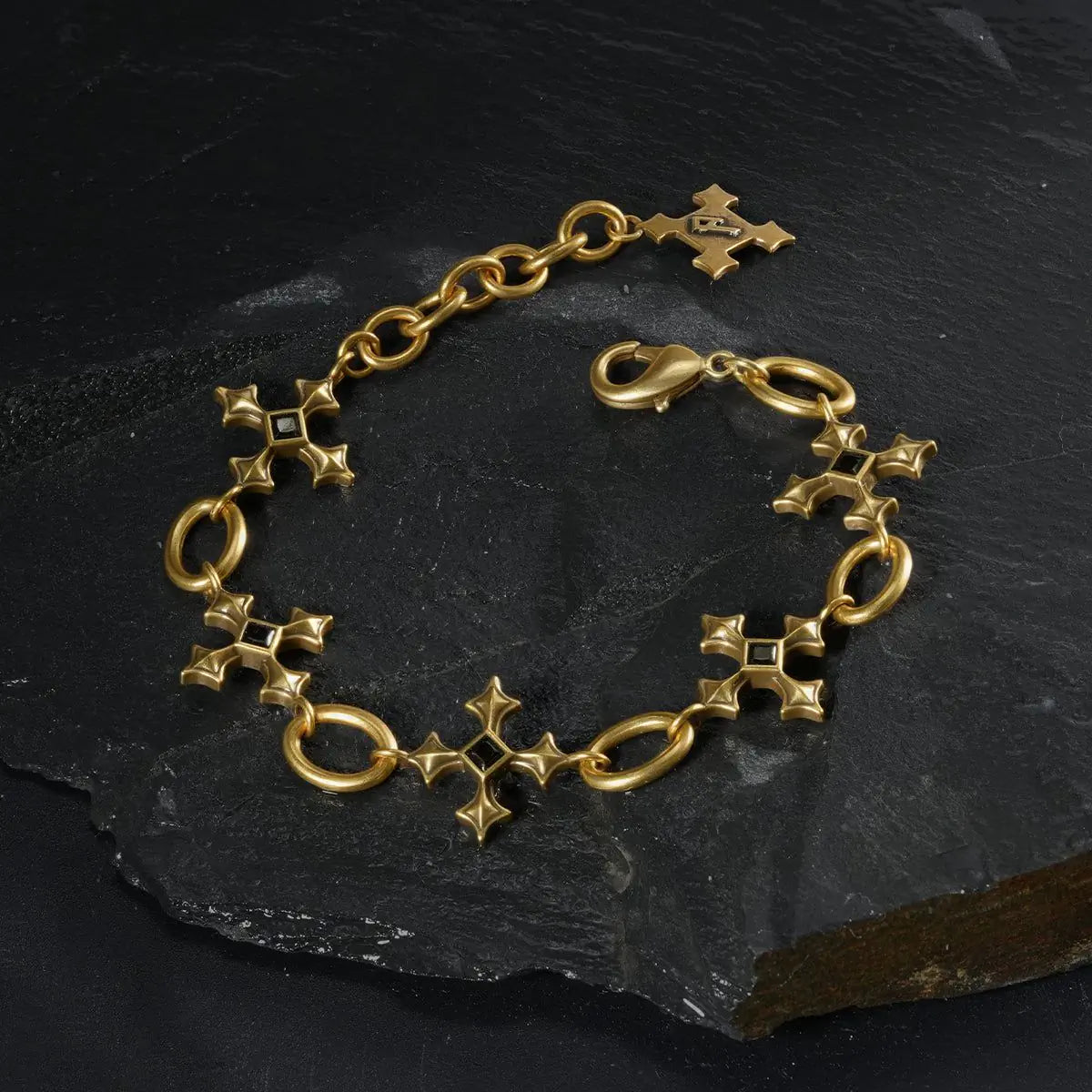 Gold Silent Litany Bracelet arranged in a full circle on black textured fabric.
