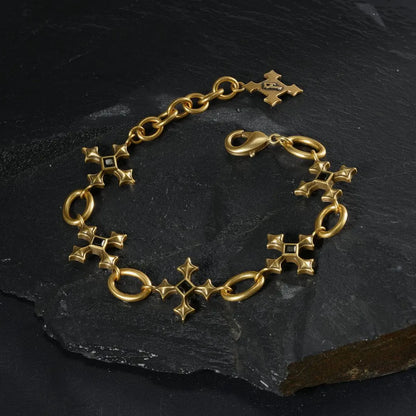 Gold Silent Litany Bracelet arranged in a full circle on black textured fabric.
