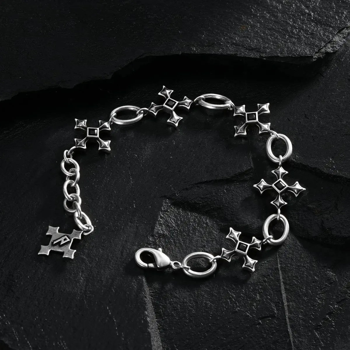 Silver Silent Litany Bracelet arranged in a full circle on black textured fabric.