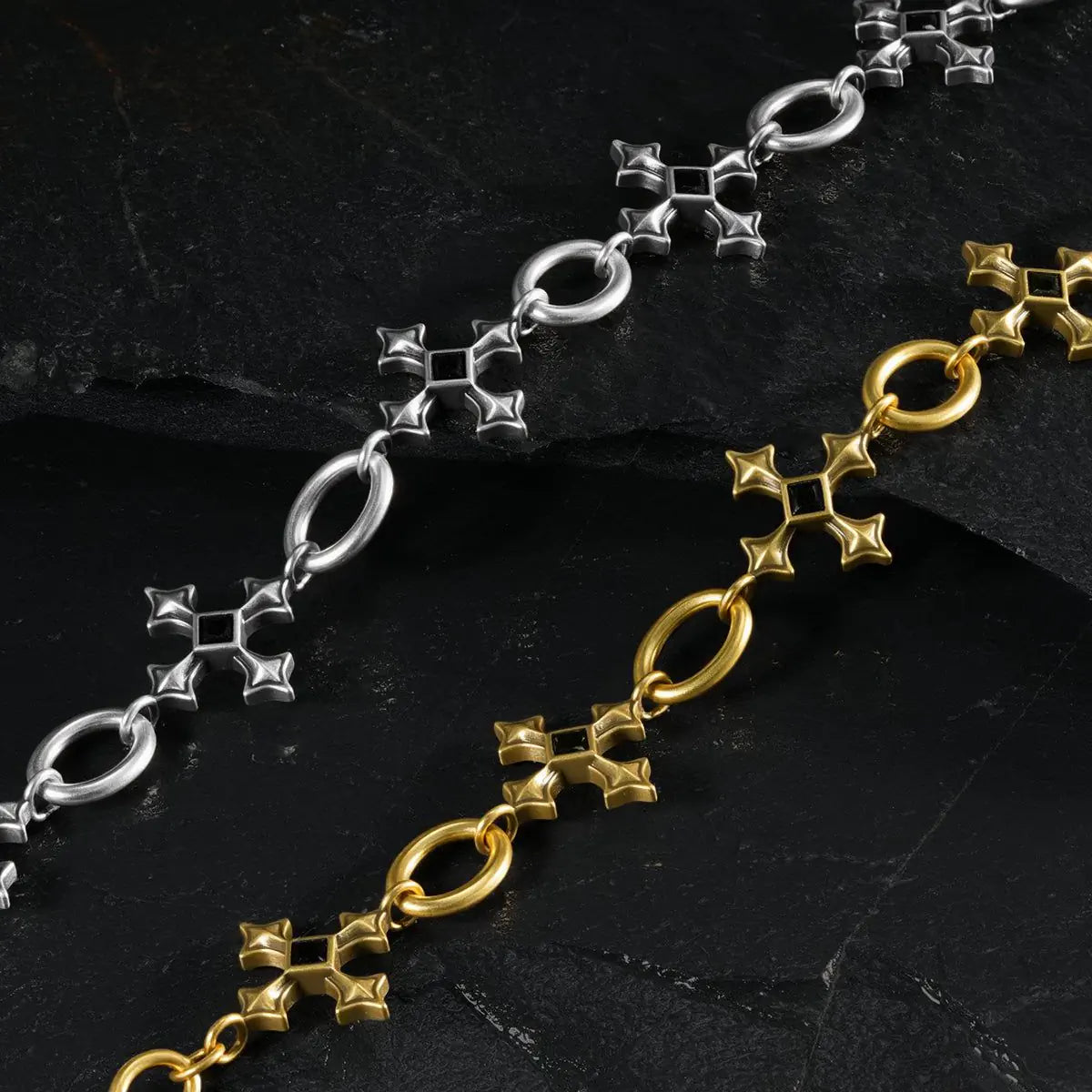 Silver and gold Silent Litany Bracelet links shown in a close diagonal arrangement on black textured fabric.