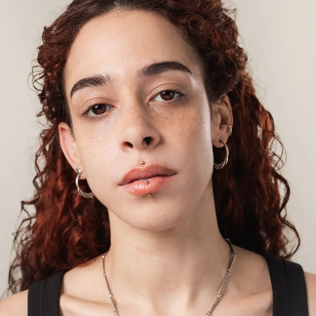 Model wearing the silver Siren Crest Earrings with a sculptural half-hoop profile and ocean-inspired gothic styling.