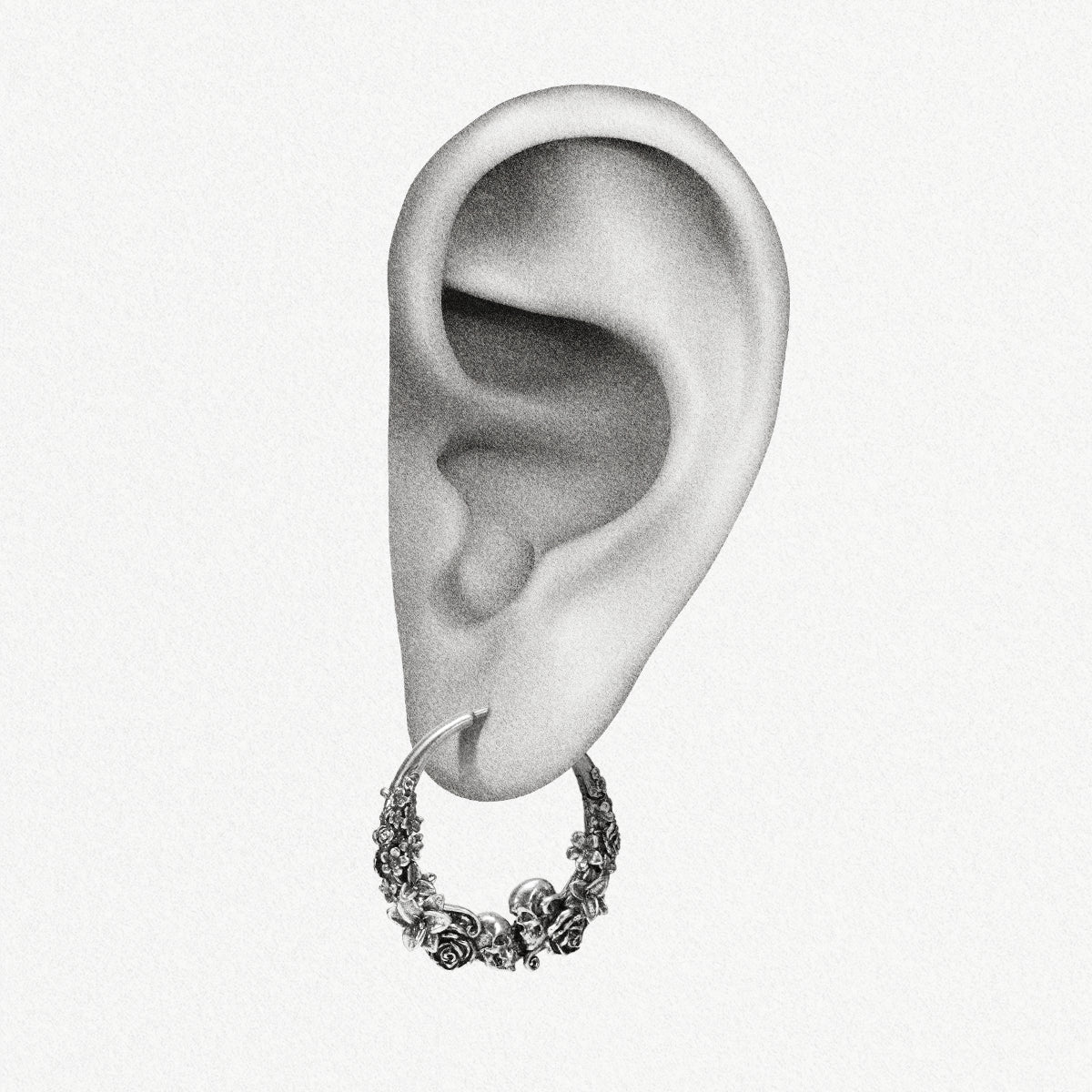 Silver Skull Blossom hoop earring shown on an ear illustration
