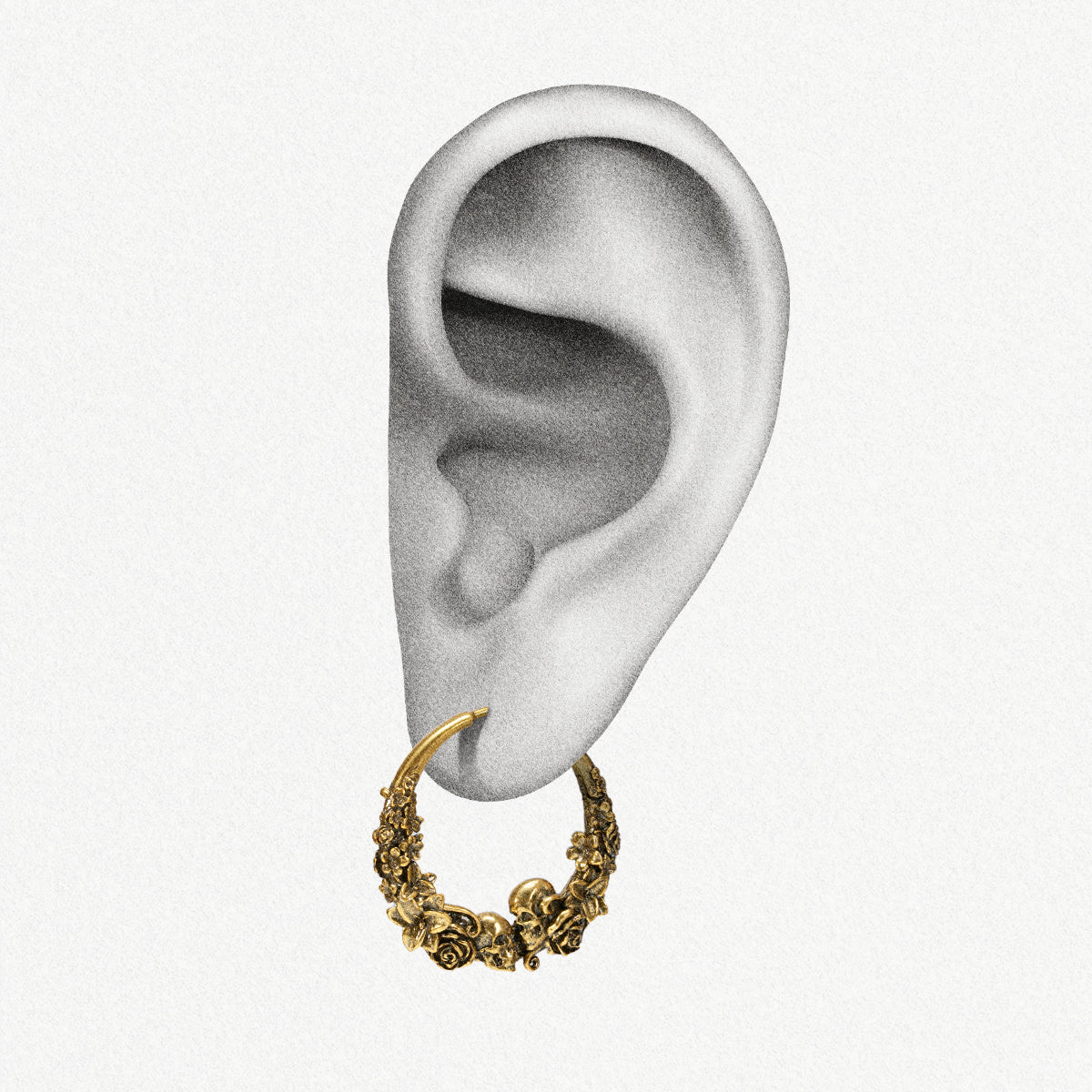 Gold Skull Blossom hoop earring shown on an ear illustration