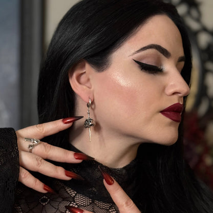 Side view of model wearing a silver Skull Dagger hoop earring