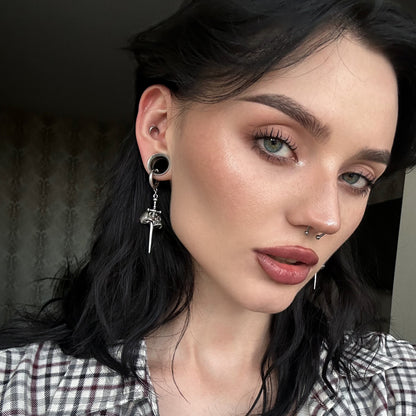 Model with black ear plug wearing a silver Skull Dagger hoop earring