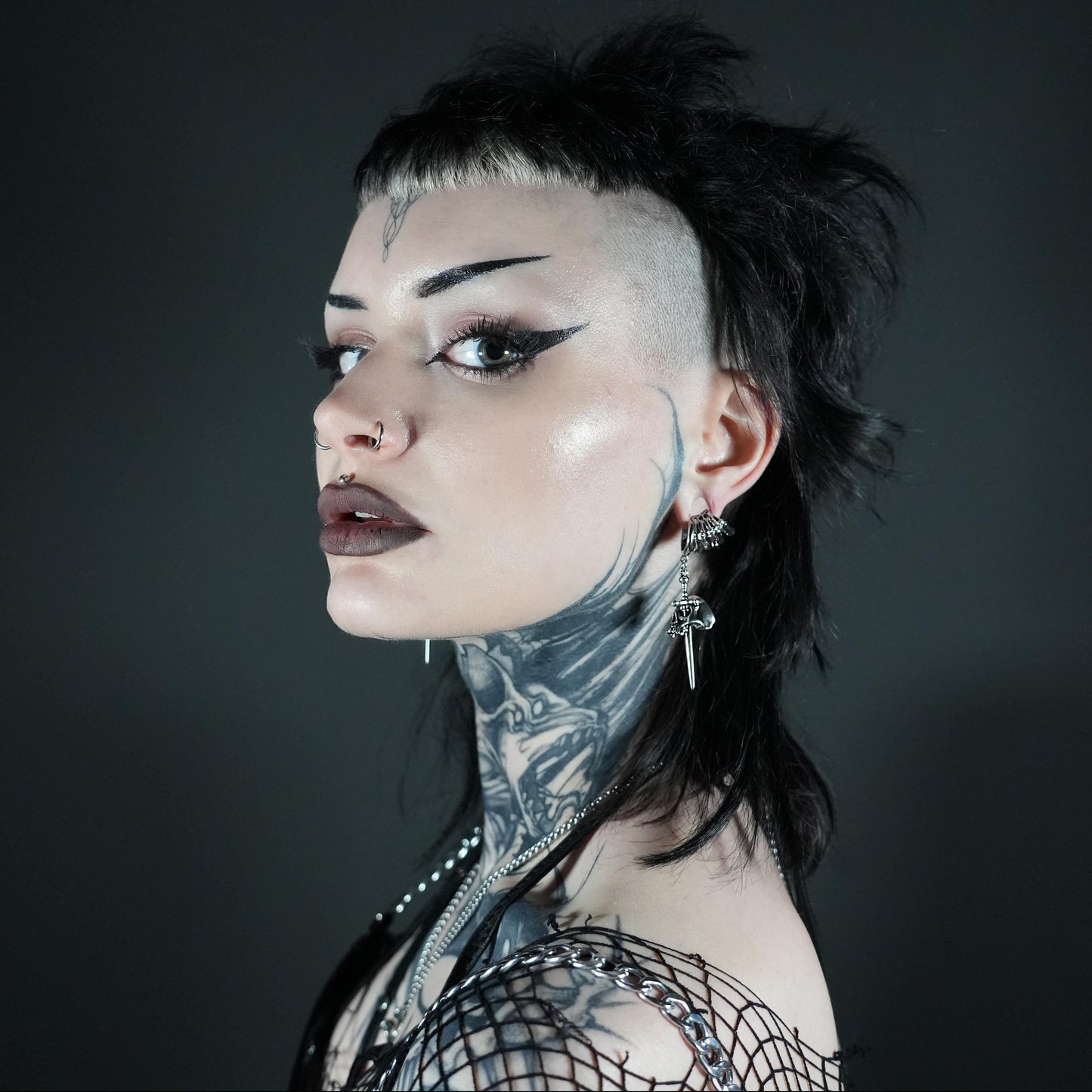 Model wearing a silver Skull Dagger earring with a short dark hairstyle