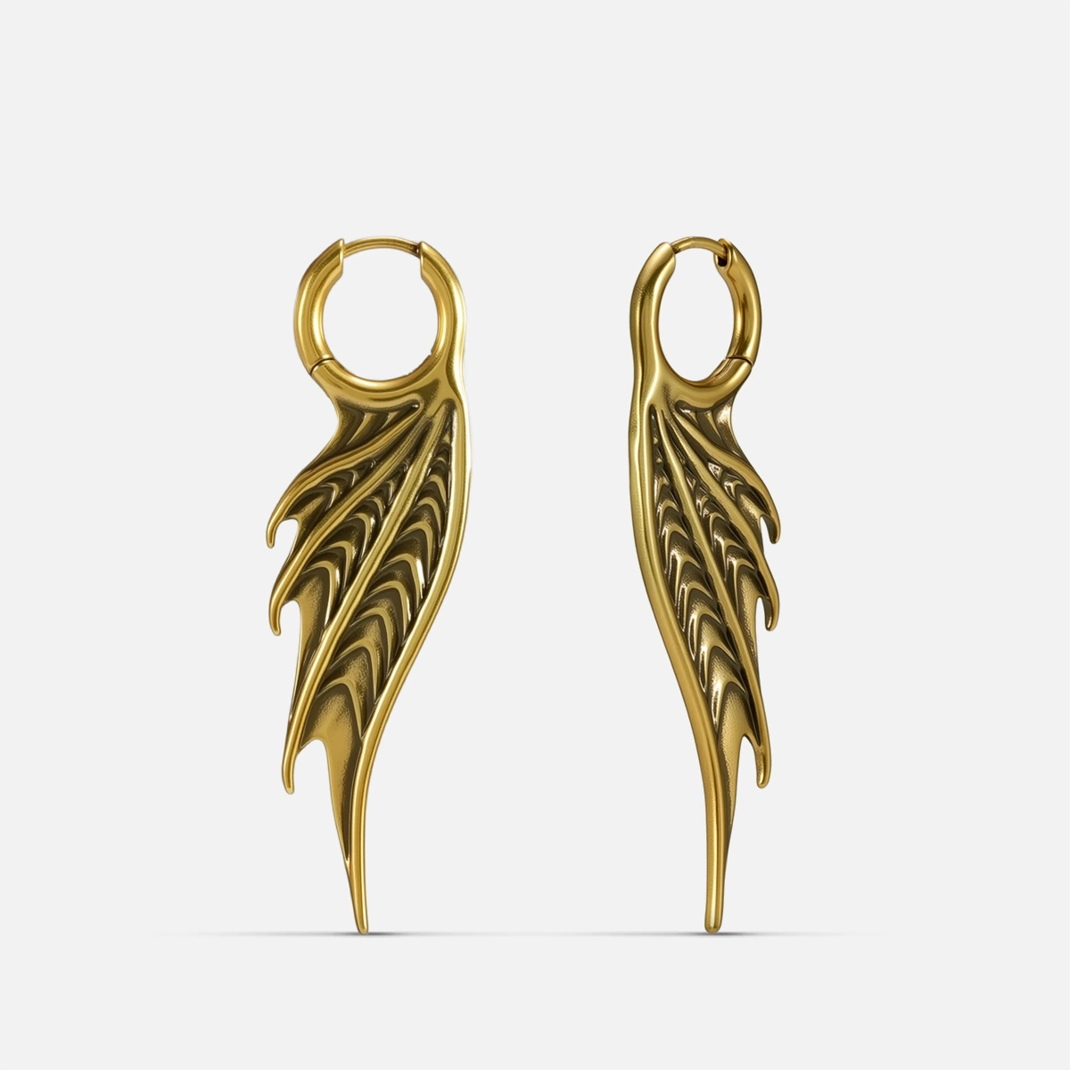 Gold Spined Wing Earrings with long ribbed wing drops, sharp fin-like ridges, and hoop design on a clean background.