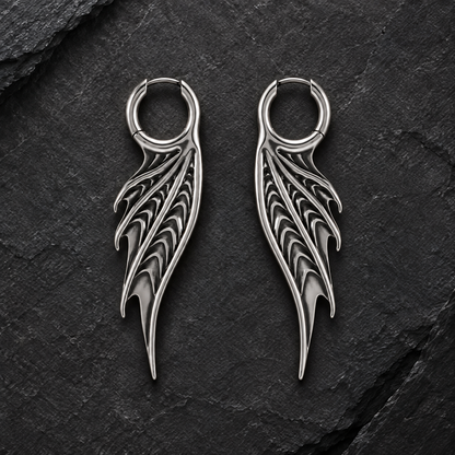 Pair of silver-tone Spined Wing hoop earrings arranged symmetrically on dark slate.
