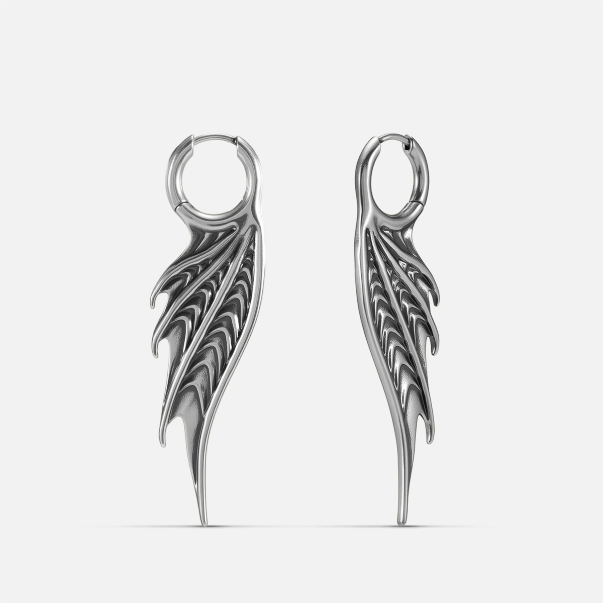Silver Spined Wing Earrings with long ribbed wing drops, sharp fin-like ridges, and hoop design on a clean background.