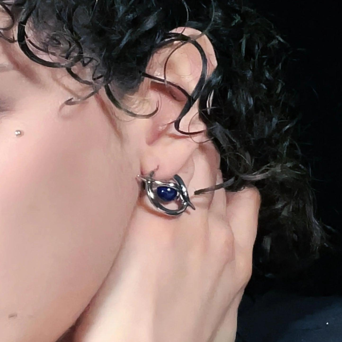 Silver Stellar Axis Earrings worn on ear with lapis gemstone and celestial orbital frame