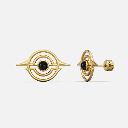 Gold-tone ear studs with concentric ring design and black stone center, front and side view