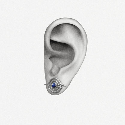 Silver Stellar Grace ear stud with blue center shown on an ear illustration