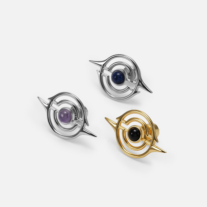 Three ear studs with concentric ring design in silver-tone and gold-tone, featuring blue, purple, and black stone centers