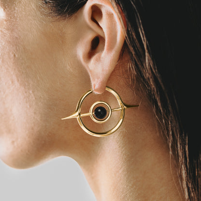Close-up of gold Stellar Grace hoop earring with black center accent