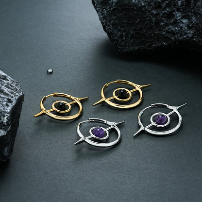 Two pairs of gold and silver Stellar Grace hoop earrings on black stone