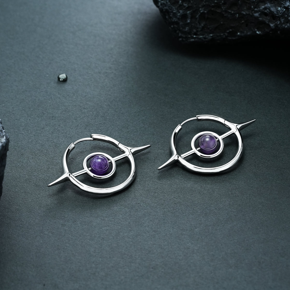 Pair of silver Stellar Grace hoop earrings with purple center accents