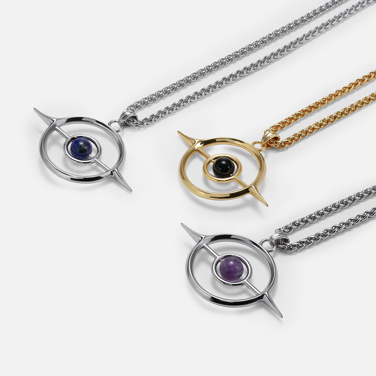 Silver and gold Stellar Grace necklaces with purple, blue, and black centers