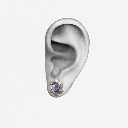 Silver Stellar Nova ear stud with purple center shown on an ear illustration