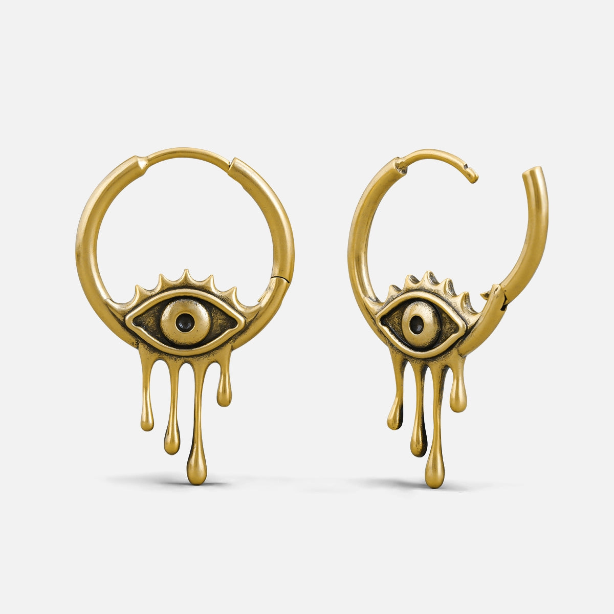 Gold-tone hoop earrings with a weeping eye charm and dripping tear detail, hinge clasp shown open and closed