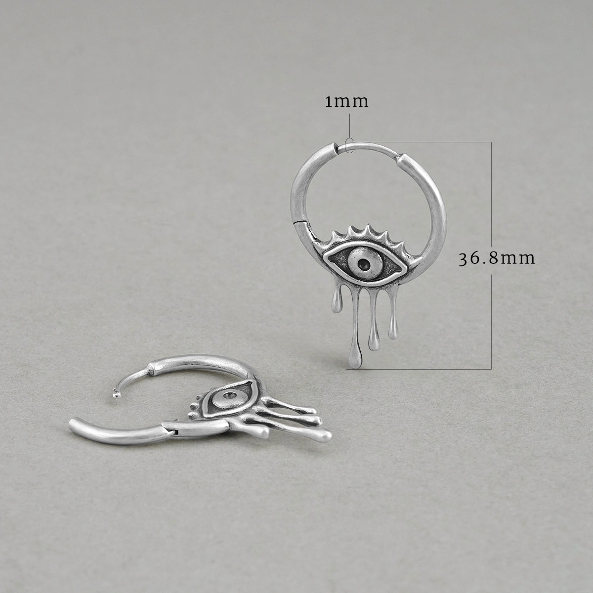 Silver Surrealist Eye hoop earring shown upright and flat with dimensions