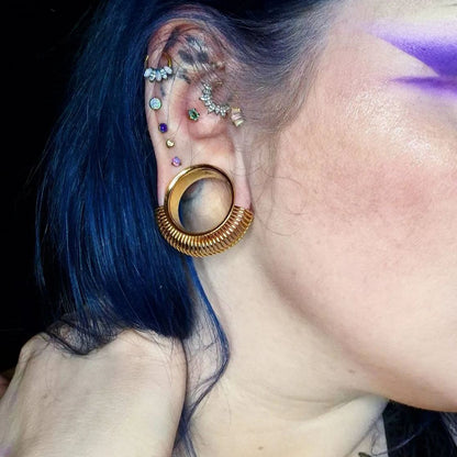 Blue-haired model wearing a gold Symmetrical Radiance tunnel
