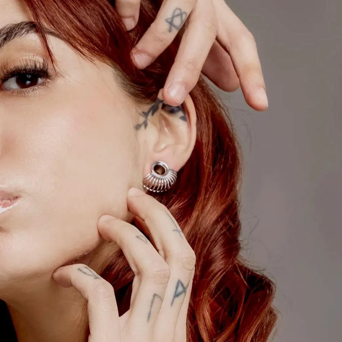 Red-haired model wearing a silver Symmetrical Radiance tunnel