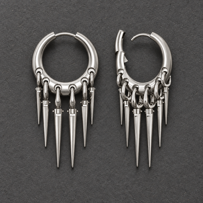 Pair of silver-tone Tapered Chic hoop earrings with graduated spike drops on a textured gray surface.