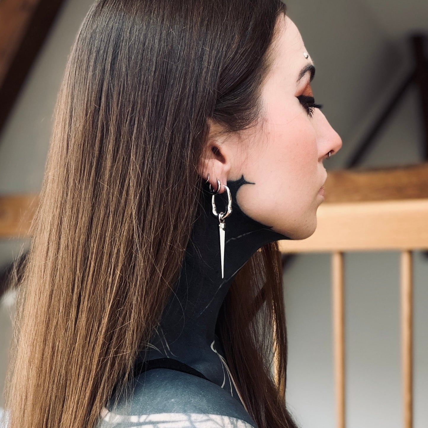Side view of model wearing a silver Tapered Edge drop earring