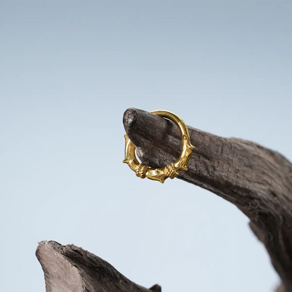 Gold Thorn Bramble Clicker displayed on weathered wood with thorned bramble design