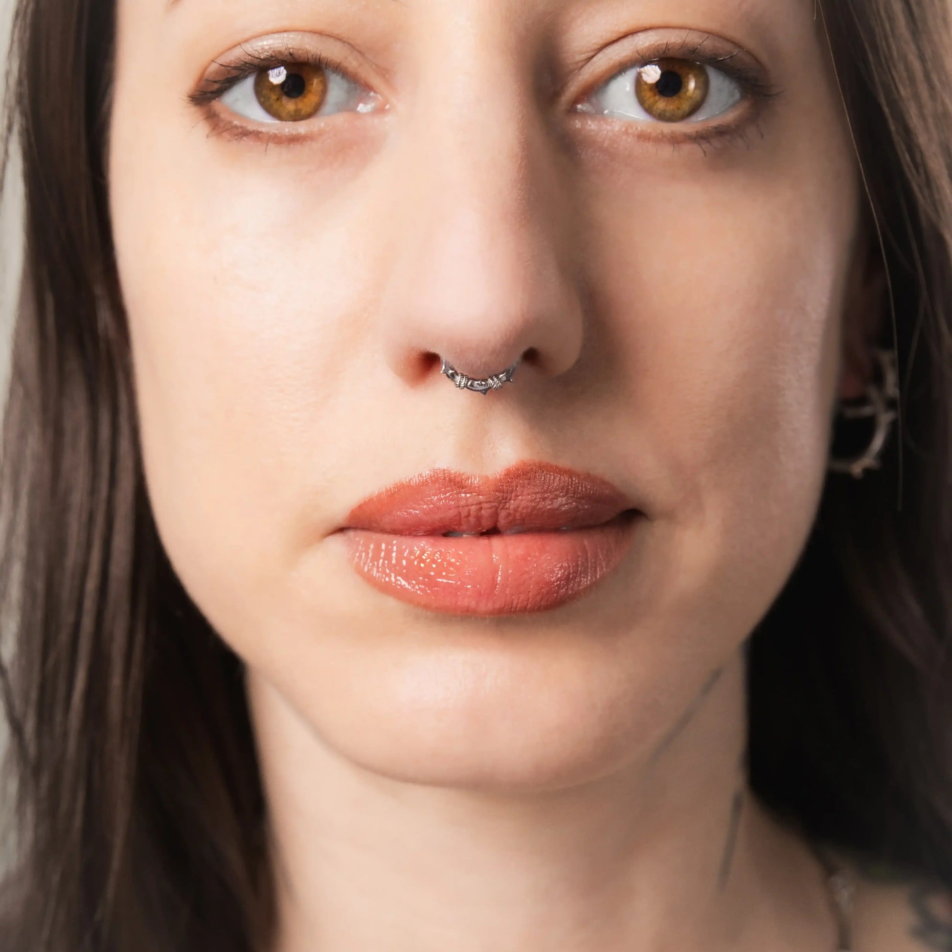 Model wearing silver Thorn Bramble Clicker with thorned septum ring design