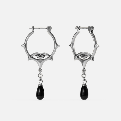 Antiqued silver-tone Thorned Gaze Hoop Earrings with open thorned frames, engraved eye motifs, and suspended black teardrop accents.