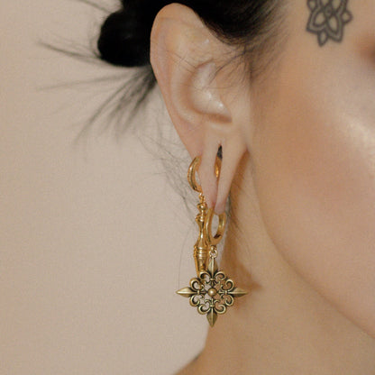 Side view of gold Timeless Spear earring worn with a floral hoop earring