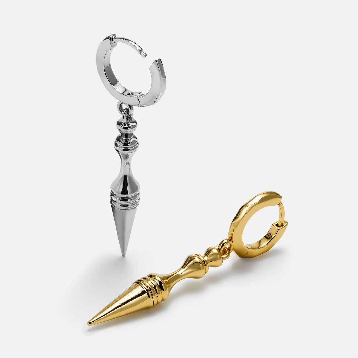 Silver and gold Timeless Spear hoop earrings shown open and lying flat
