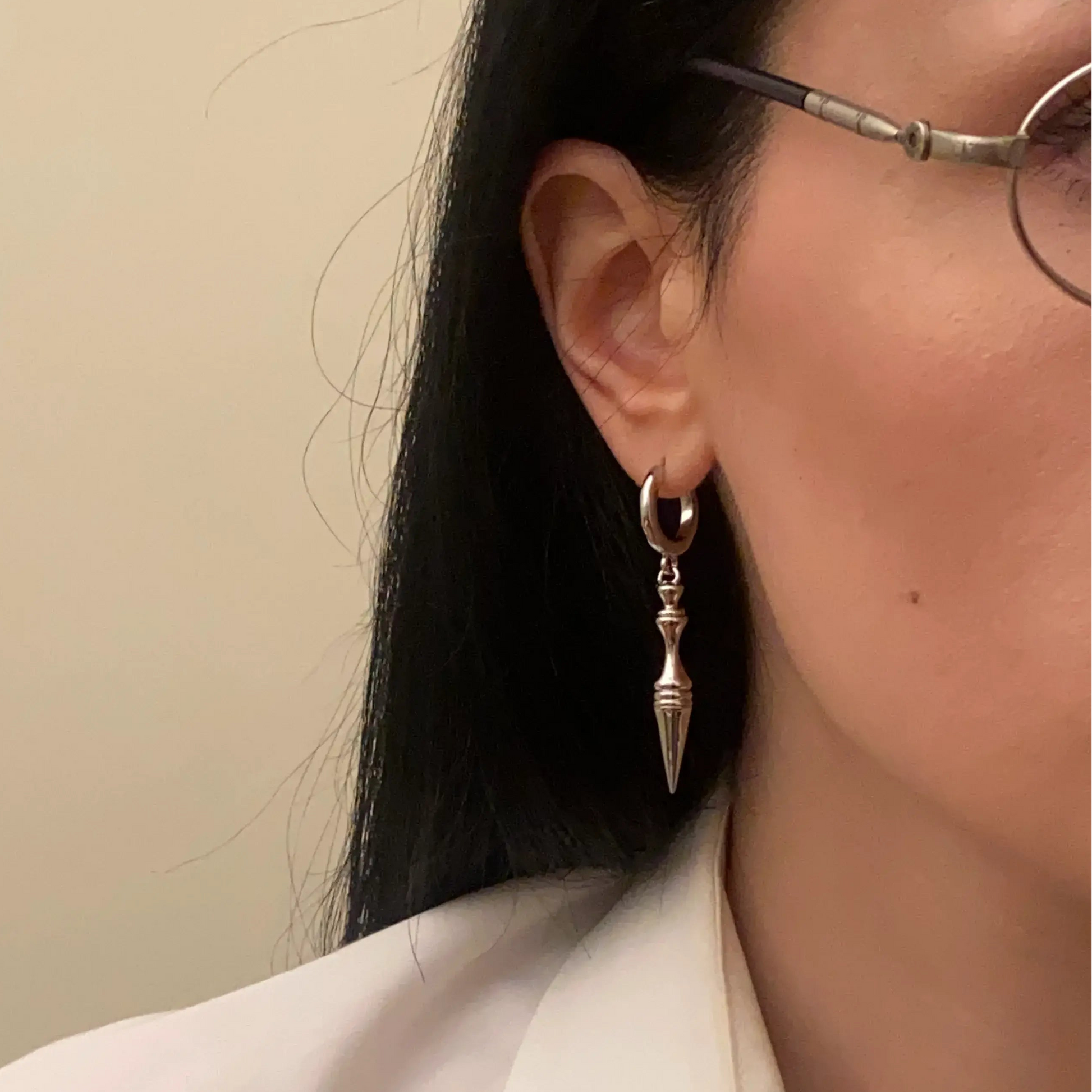 timeless spear earrings shown on a model in side view, featuring silver hoop earrings with sleek spear-shaped drops