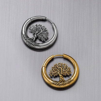 Silver-tone and gold-tone tree of life hoop earrings laid flat side by side