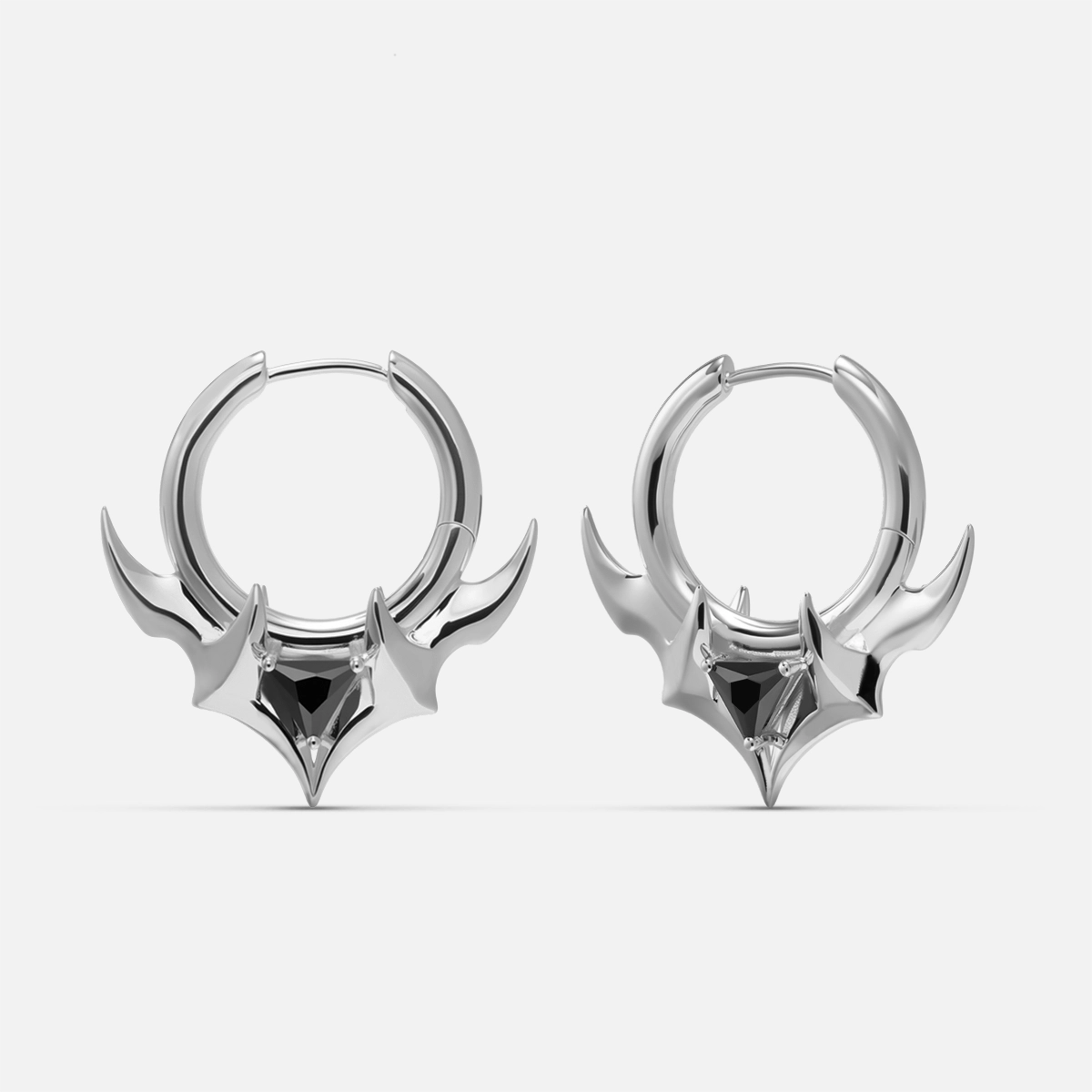 Silver-tone hoop earrings with curved horn shapes and a black stone at the center, front view