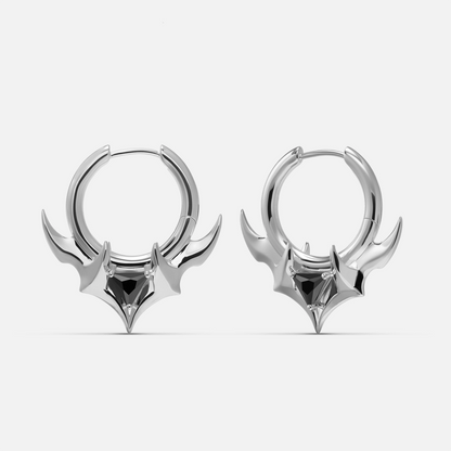 Silver-tone hoop earrings with curved horn shapes and a black stone at the center, front view