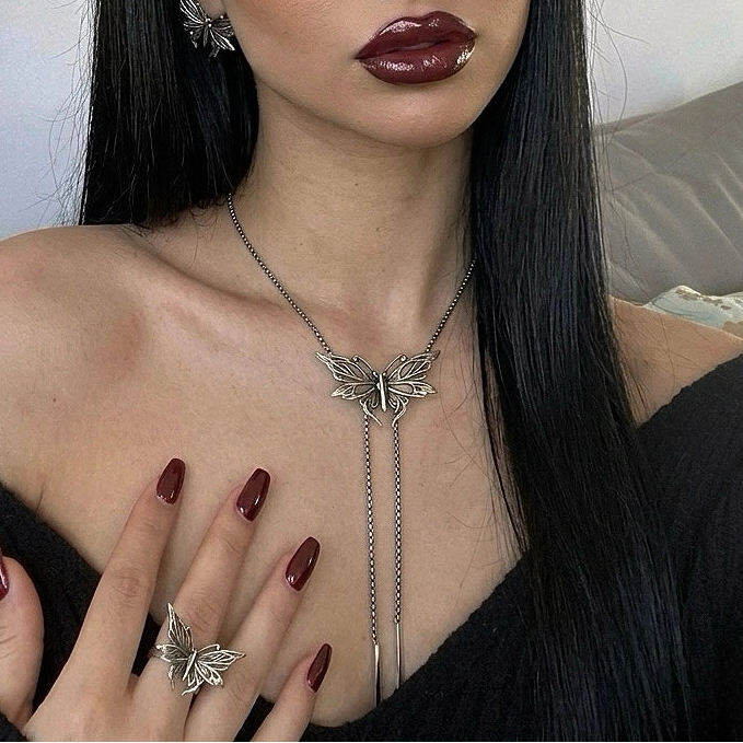 twilight moth necklace shown in a model view, featuring a silver moth pendant necklace with long chain drops worn at the neckline
