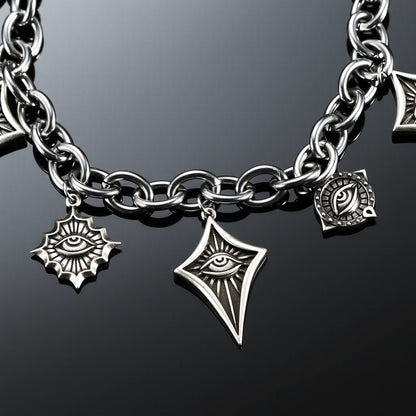 Close-up of the antiqued silver-tone Unblinking Procession Bracelet showing radiating and pointed eye charms on a dark reflective surface.