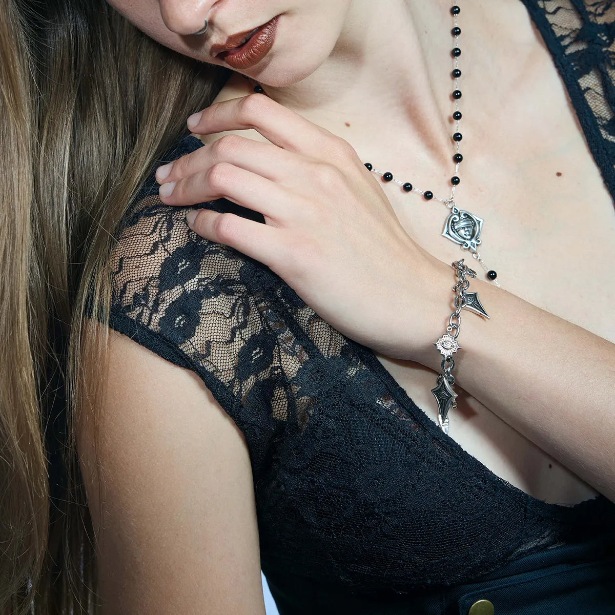 Antiqued silver-tone Unblinking Procession Bracelet worn in a styled portrait, showing the link chain and varied eye charms.