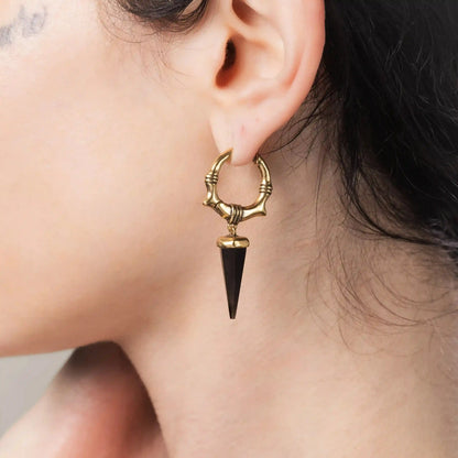 Model wearing gold Unearthed Spike Earrings with black obsidian spike drops and bone-textured hoops