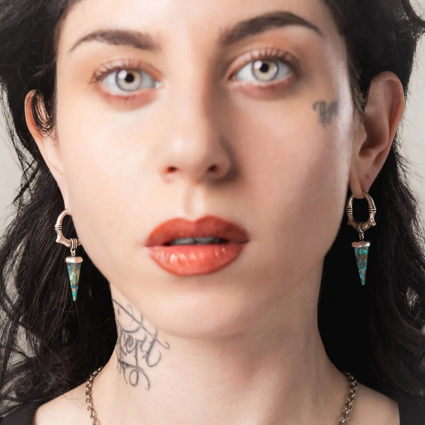 Model wearing silver Unearthed Spike Earrings with faceted turquoise spike pendants